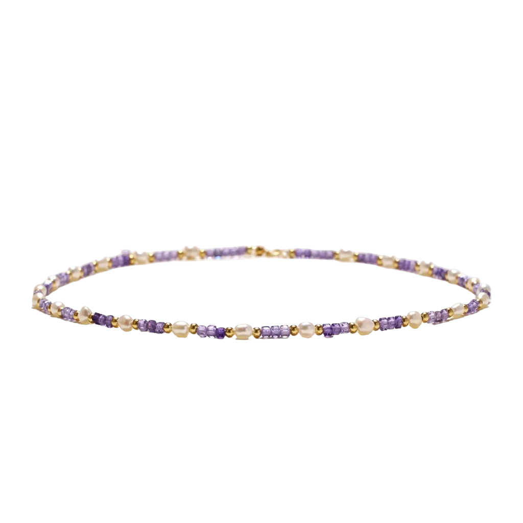 Low-angle view of Ljubica necklace with freshwater pearls, violet zirconia cubes and gold vermeil beads