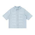 Front view of light blue lyocell shirt with white New York and inverted Pizdets lettering
