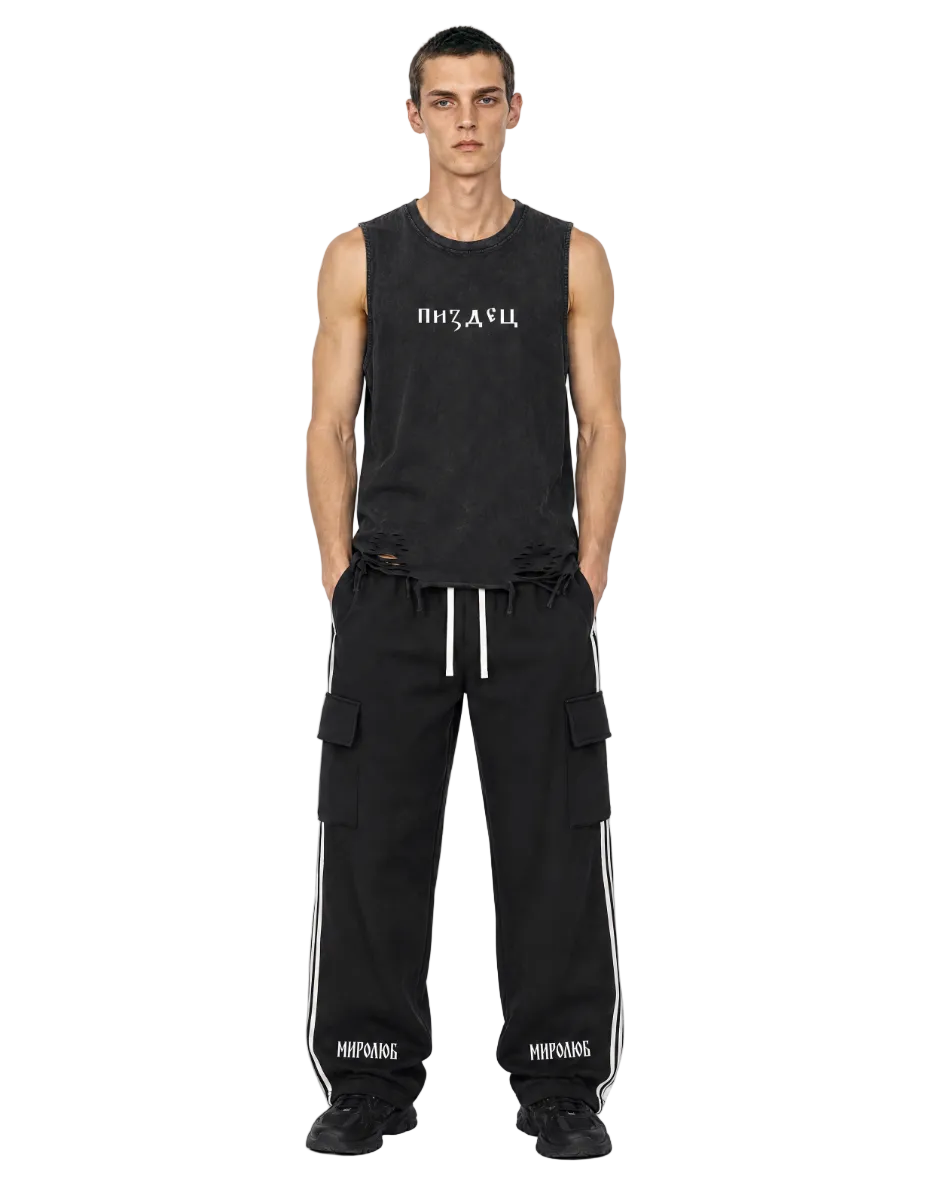 Model wearing black MIROLYUB Wordmark side-stripe pants with a black raw-hem tank.