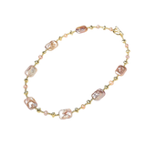 Angled full view of Rumenka pink freshwater pearl necklace with gold-plated beads and a toggle clasp