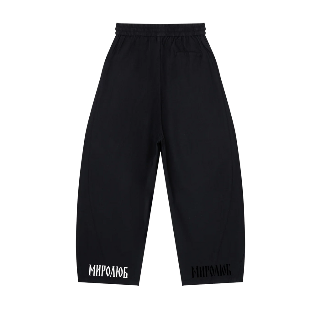 Black MIROLYUB wide-leg drawstring pants with wordmarks at the hems, back view.