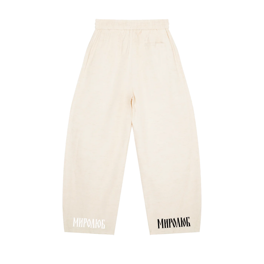 Cream MIROLYUB wide-leg drawstring pants with wordmarks at the hems, back view.