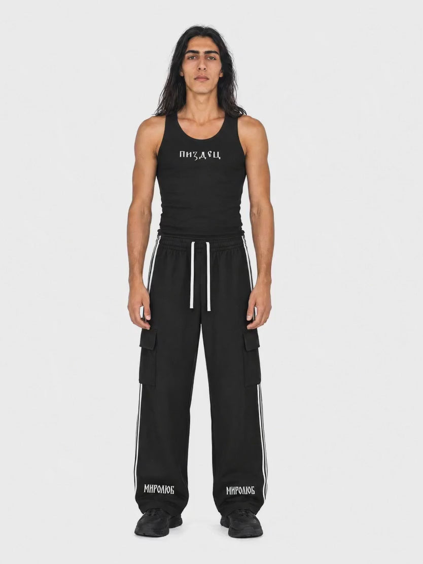 Ciro wearing the black MIROLYUB Pizdets fitted tank and Wordmark side-stripe pants, rotating from front to back.